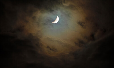 Wall Mural - Warm glow of the moon through an opening in the clouds