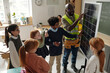 © pressmaster - Cute primary schoolboy and professional engineer touching solar panel during presentation of renewable sources of energy