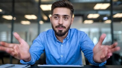 Poster - A man in a blue shirt gestures while speaking in an office setting.