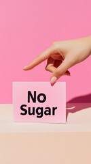 Poster - Hand pointing at pink no sugar sign on beige background, promoting healthy lifestyle