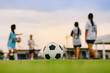 © nateejindakum - Action sport outdoors of kids having fun playing soccer football for exercise in community rural area under the twilight sunset sky.