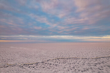 Wall Mural - Aerial view on an ice on the Onega lake covered with ice in Republiс of Karelia in winter in a sunset