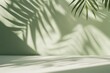 © Marina Demidiuk - Minimal abstract background, light and shadow of tree leaves. Cosmetic product presentation. Premium podium. Pastel soft green wall, white table. Showcase display case. Front view. Mockup ad. Concrete