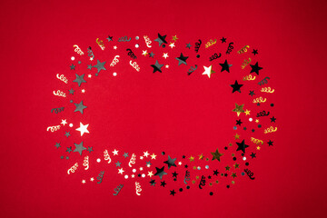 Wall Mural - christmas modern composition. golden decorations, confetti, streamers, stars on red background. chri