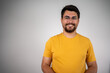 © Nenad - Portrait of a happy young casual man standing. portrait of young smiling handsome guy in yellow t-shirt isolated on gray background