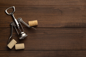 Canvas Print - Wing corkscrew and corks on wooden table, flat lay. Space for text