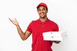 © luismolinero - African American pizza delivery man picking up pizza boxes over isolated white wall extending hands to the side for inviting to come