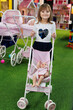 © Studio Peace - Cute little girl is playing with a doll and a stroller in a modern playroom.