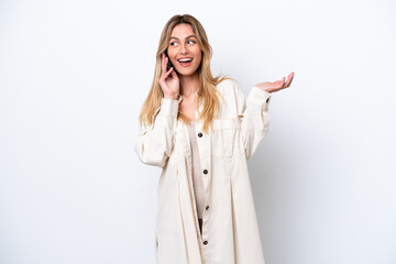 Canvas Print - Young Uruguayan woman isolated on white background keeping a conversation with the mobile phone with someone