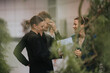 © qunica.com - Group of three colleagues laughing and discussing work while standing outdoors, showcasing a friendly and relaxed atmosphere.