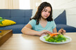© AntonioDiaz - Teen girl with eating disorder and health problems rejecting fresh salad during home lunch