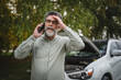 © Miljan Živković - worried man stand in front open hood of car make a phone call for help