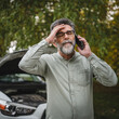 © Miljan Živković - worried man stand in front open hood of car make a phone call for help