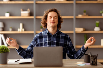 Poster - Young Businessman Meditating Sitting With Eyes Closed Relaxing At Workplace In Modern Office. Man Doing Meditation Relaxation Exercise Indoors. Keep Calm Concept. Selective Focus