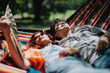 © qunica.com - Happy couple lounging together in a colorful hammock under the sun, enjoying a relaxing day outdoors in nature.
