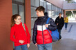 © JackF - Portrait of two students carrying bags walking and talking on the street