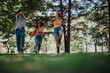 © qunica.com - Three young teenagers enjoying a playful and joyful moment in the park, capturing their friendship and happiness