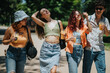 © qunica.com - Group of young friends having a great time on a sunny day in the park, enjoying refreshing drinks and smiling.