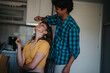 © qunica.com - A cheerful young couple shares a playful moment in a cozy kitchen, highlighting joy and companionship. The scene reflects warmth and casual intimacy in a home setting.