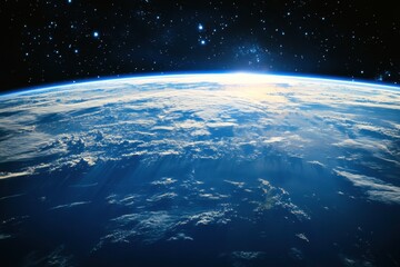 Wall Mural - Sunrise over Earth from space, with a blue atmosphere and white clouds.
