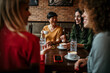 © La Famiglia - Happy young people enjoy coffee and chat, gathering in a relaxed and social environment.