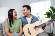 © Kawee - Asian couple spending free leisure time together in living room in house.