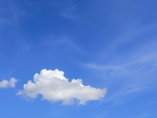 light grey clouds float against a backdrop of bright blue and swirling purple hues, nature, blue