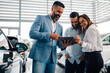 © Zamrznuti tonovi - Trio discussing car purchase options using a digital platform