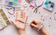 © Olena Rudo - Child making beaded bracelets at home on pink tiled table