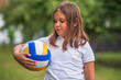 © Ljustina - Young girl holding volleyball in green park enjoys summer activity