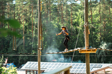 Wall Mural - a skilled individual expertly navigating a challenging high ropes course surrounded by vibrant, lush