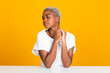 © Westend61 - Woman sitting with eyes closed at table against yellow background