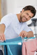 © auremar - man spreading clothes on an airer