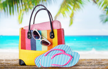Poster - A beach bag with towels, sunglasses, and flip flops placed on a table
