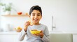 © Anna - Smiling child enjoying apple slices with peanut butter in modern kitchen