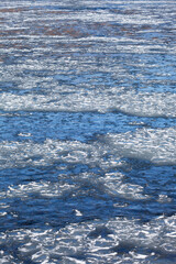 Wall Mural - Top view of the Irkut River bed with transparent blue water and ice floes float down river during freeze-up in November sunny cold clear day. Natural water background of change seasons