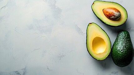 Fototapete - Isolated on white background a halved avocado showcasing its creamy interior and seed next to a whole avocado with side empty space for text Stockphoto style