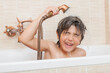 © Oriol Roca - A boy is in a bathtub with a shower head on his head