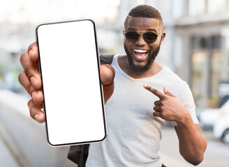 Aufkleber - Great Offer. Portrait of excited black man standing outdoors holding big phone with white blank screen in hand, showing close to camera pointing at device. Gadget with empty free space for mock up