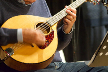 close-up of musician hands that play an mandolin in a theatre concert