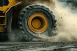 © wayan - Powerful Heavy Machinery in Action: A Close-Up of a Massive Wheel Kicking Up Dust and Debris During Construction or Mining Operations