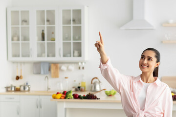 Aufkleber - Smart Home Concept. Millennial Woman Pointing Finger Up Pushing Button On Invisible Screen Standing In Kitchen Interior Indoor. Modern Futuristic House Control System, IoT Technologies Concept