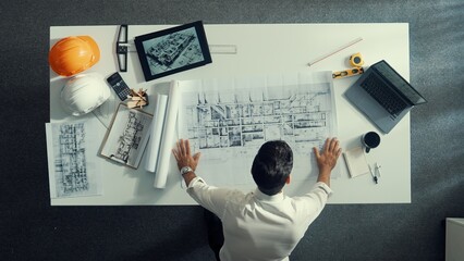 Poster - top view of skilled civil engineer sitting and writing idea while looking at house model. aerial vie