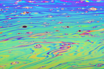 Wall Mural - Real photograph of a colorful light diffraction on a soap bubble surface with random swirls, curves and lines that look like waves on water of a pond