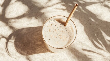 Poster - A glass of almond milk with a bamboo straw, isolated on a light textured background with almond accents