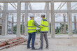 © reewungjunerr - Two Asian engineer working at site of a large building project,Work overtime at construction site,Team of engineer discus at site,The architect, supervisor, and foreman meet to discuss the design