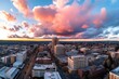 © Thanyarat - A panoramic aerial view of a city at dusk, with the last rays of sunlight fading behind the buildings
