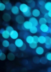 Wall Mural - an abstract image featuring a bokeh effect with numerous out of focus blue and teal circles on a dar