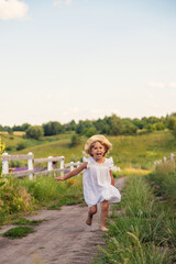 Poster - A child runs across a field in a village. Selective focus.