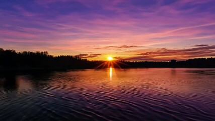 Wall Mural - Sunset Serenity: Vibrant hues paint the sky as the sun dips below the horizon, casting a warm glow on the tranquil lake. Serene landscape photography. 